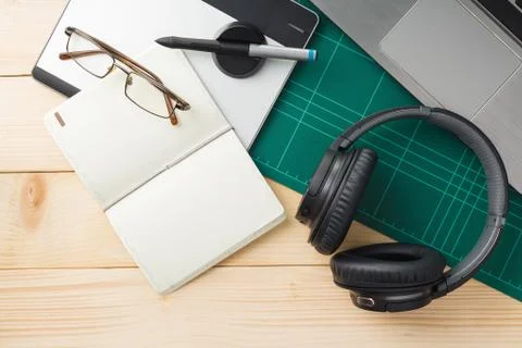 Top view of stuff and gadgets on wooden desk with graphic designer equipment. Stock Photos