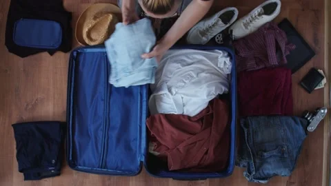 A top view of the suitcase and the things around it that a young guy with Stock Footage 135649613