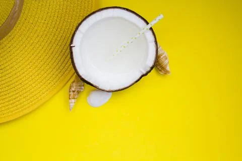 Top view of summer hat and coconut water on yellow background with copy space Foto stock