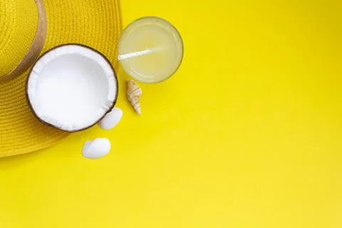 Top view of summer hat, coconut and glass with coconut water on yellow backgr Stock Photos