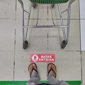 Top view of a supermarket queue limit sign on the floor with a shopping car.. Stock Photos