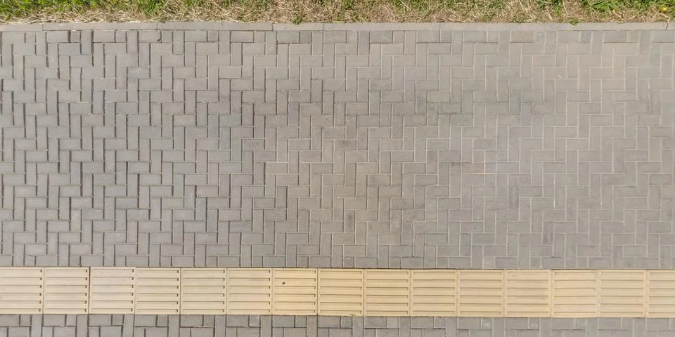 Top view of surface of pedestrian path with paving slabs with the border of l Stockfoto's