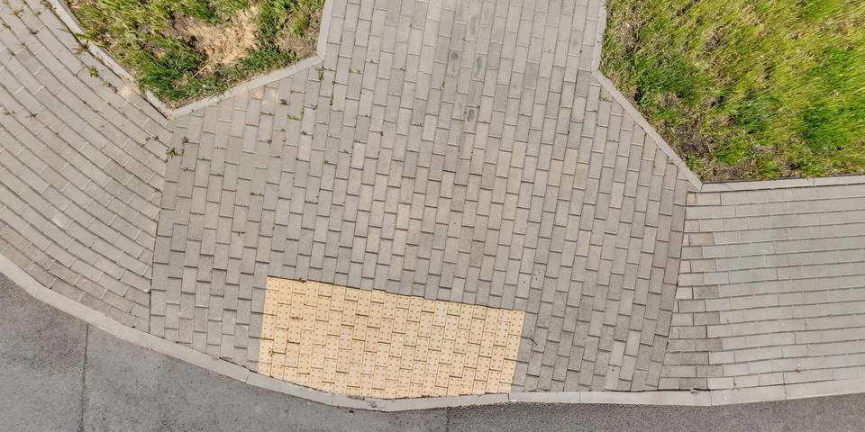 Top view of surface of pedestrian path with paving slabs with the border of l Stockfoto's
