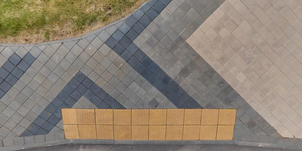 Top view of surface of pedestrian path with paving slabs with the border of l Stock Photos