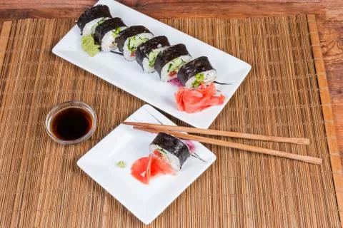 Top view of sushi on rectangular plates, condiments, chopsticks Stock Photos