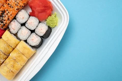 Top view on sushi set at colored background. Plate with rolls, ginger and vas Stock Photos