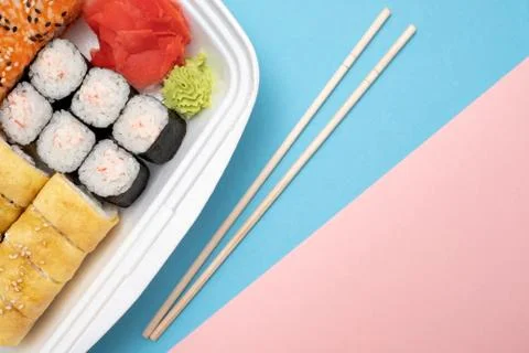 Top view on sushi set at colored background. Plate with rolls, ginger and vas Stock Photos