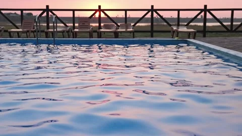 Top view of swimming pool with clear water on vacation on sunset background Stock Footage 348086735