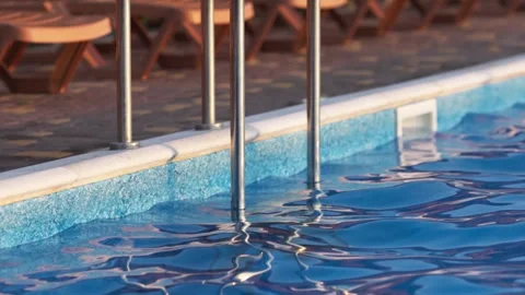 Top view of swimming pool with clear water on vacation on sunset background Stock Footage 348131885