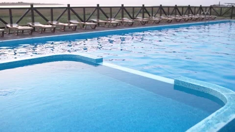 Top view of swimming pool with clear water on vacation on sunset background Stock Footage 348402209