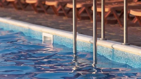 Top view of swimming pool with clear water on vacation on sunset background Stock Footage 348683744