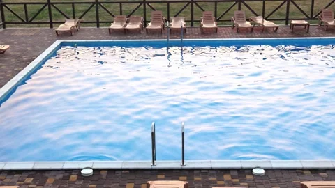 Top view of swimming pool with clear water on vacation on sunset background Stock Footage 348689065