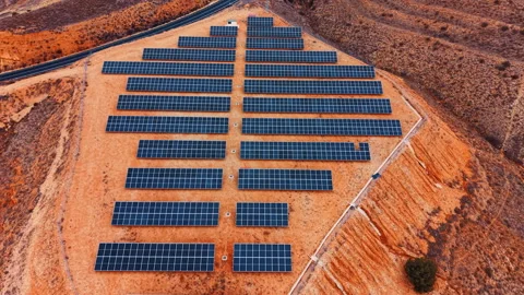 Top view of symmetrical solar panel array on red soil Stock Footage 330789361