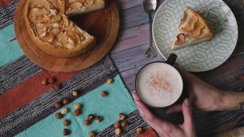 Top view of the table de lies an apple pie and a cup of coffee. Denny's hands Stock Footage 139148673