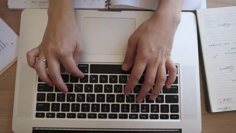Top view of a table as female hands typing on a laptop. Stock Footage 136365414