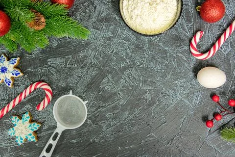 Top view of table with flour, egg, strainer, sugar sticks and christmas holid Stock Photos
