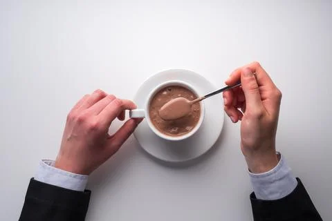Top view table with hands and chocolate in cup. White background Stock Photos