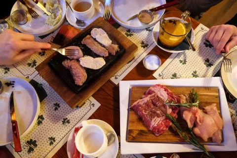 Top view of table in Irish pub. Meat grilled without oil on hot volcanic ston Stock Photos