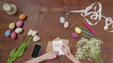 Top view of a table with items to create a composition for Easter. A woman's Video stock 171464980