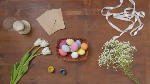 Top view of a table with items to create a composition for Easter. Women's hands Video stock 171475250