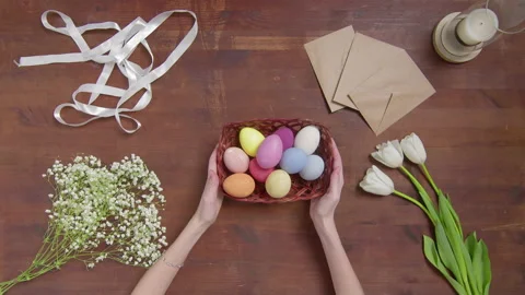 Top view of a table with items to create a composition for Easter. Women's hands Video stock 176384994