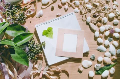 Top view on the table. Romantic desk. Notebook, sea stones, design items. Stock Photos