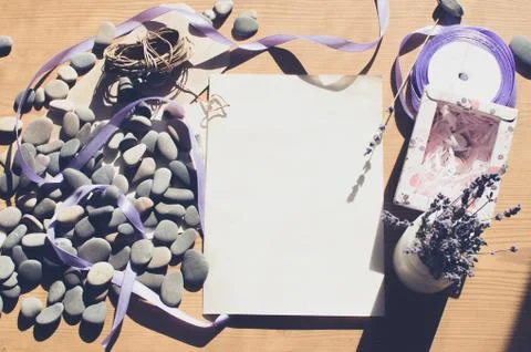 Top view on the table. Romantic desk. Notebook, sea stones, design items. Stock Photos