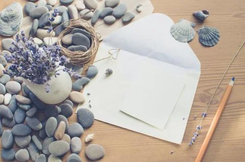 Top view on the table. Romantic desk. Notebook, sea stones, design items. Stock Photos