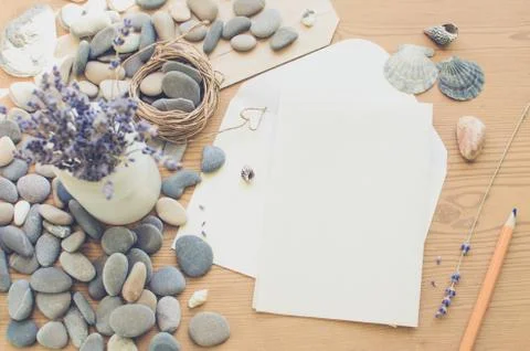 Top view on the table. Romantic desk. Notebook, sea stones, design items. Stock Photos