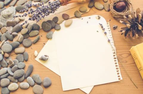 Top view on the table. Romantic desk. Notebook, sea stones, design items. Stock Photos