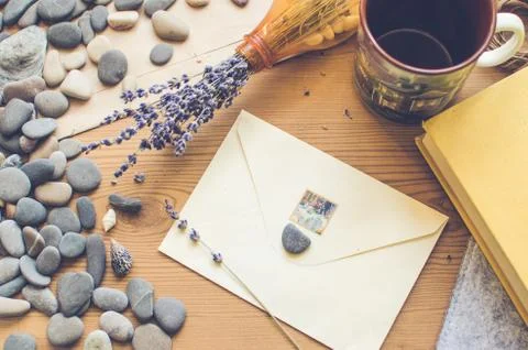Top view on the table. Romantic desk. Envelope, sea stones, design items. Stock Photos