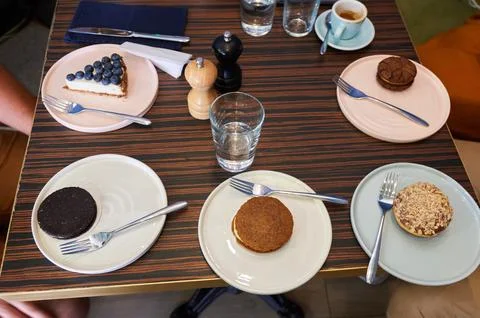 Top View Table Setting with Various Desserts, Coffee and Water in Cafe Stock Photos