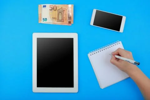 Top view on the tablet, Notepad with pen, phone and Euro banknotes Stock Photos