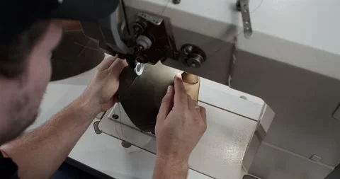 Top view of tailor works on sewing machine in private leather craftshop, making Stock Footage 200127497