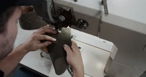Top view of tailor works on sewing machine in private leather craftshop, making Stock Footage 200127543