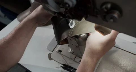 Top view of tailor works on sewing machine in private leather craftshop, making Stock Footage 200127553