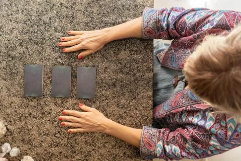 Top view of a tarot reader and three cards turned face down Stock Photos