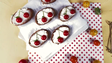 Top view of tartines with cherry tomato decoration on a yellow background and po Stock Footage 304459061