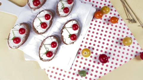 Top view of tartines with cherry tomato decoration on a yellow background and po Vidéo 304459083