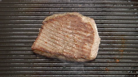 TOP VIEW: Tasty beef steak fries on a grill Stock Footage 68489576