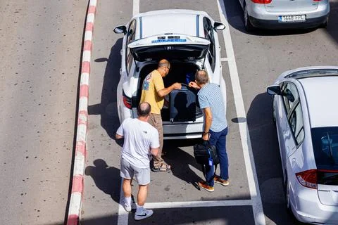 Top view of the taxi driver loading a tourist's luggage into the car Stock Photos