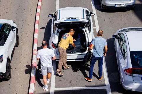 Top view of the taxi driver loading a tourist's luggage into the car Stock Photos
