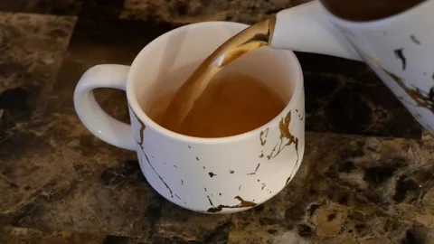 Top View of Tea Being Poured Into a Marble Cup Stock Footage 161670955