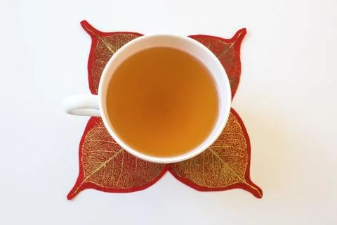 Top view of tea in cup surrounded by red and gold paper leaves, isolated Stock Photos