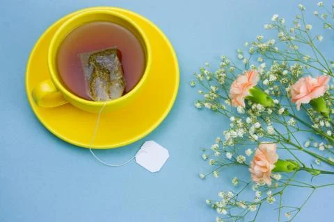 Top view tea cup with tea bag and bouquet of flowers Stock Photos
