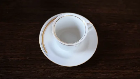 Top view of tea from the kettle slowly pour into porcelain cup Stock Footage 128429123