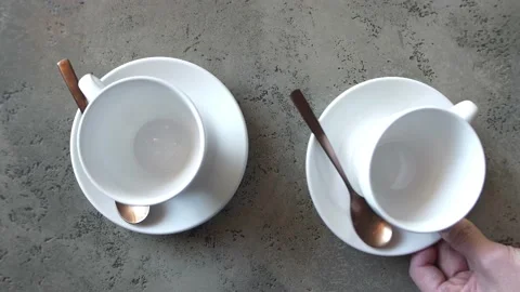 Top view of a tea pair of white cups on white saucers on a light table. Video stock 168516029