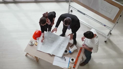 Top view of a team of engineers standing around their desks in the meeting room. Stock Footage 140339876