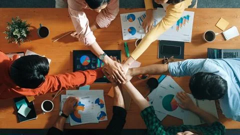 Top view of team put hands together at table with financial chart. Convocation Stock Photos