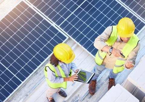 Top view, teamwork and engineers with tablet on solar roof for maintenance 写真素材